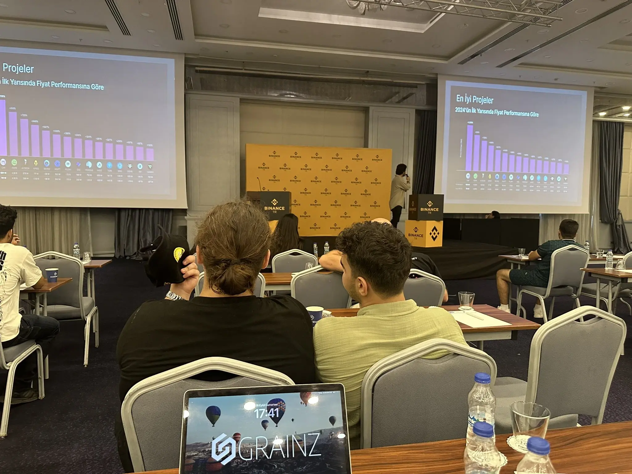 Burak Gökmen Çelik ve GRAINZ Studio kurucuları Binance Global ve Binance TR etkinliğinde, konferans salonunda sunum yapılırken